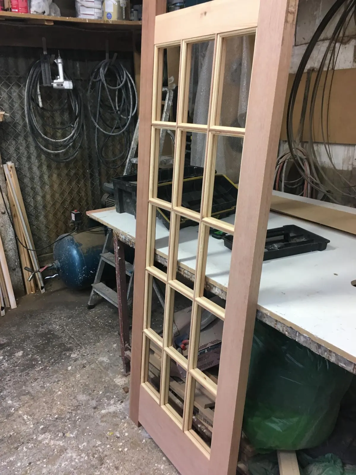 Part-glazed timber door leaf awaiting finishing in the workshop